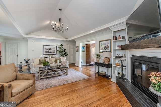 living room with an inviting chandelier, light wood-type flooring, crown molding, and vaulted ceiling