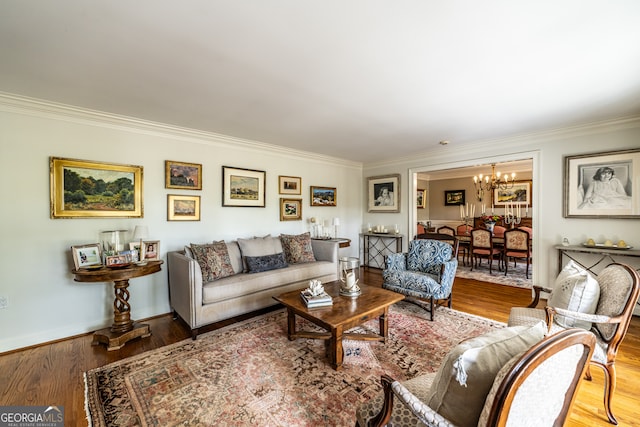 living room featuring crown molding, hardwood / wood-style floors, and an inviting chandelier