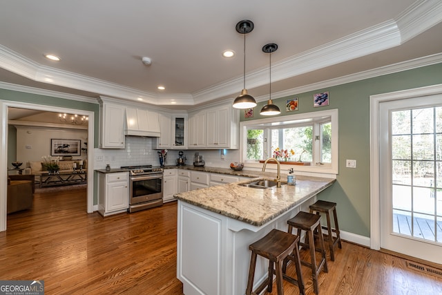 kitchen featuring a wealth of natural light, white cabinetry, sink, and stainless steel stove