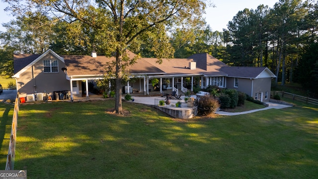 rear view of house featuring a yard and a patio