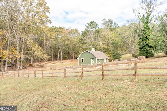 view of yard featuring a rural view and an outbuilding