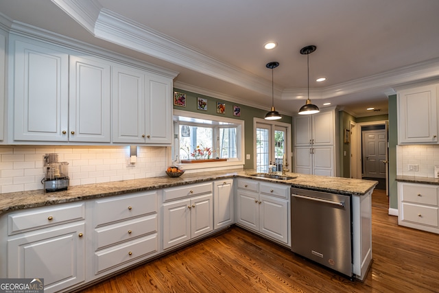 kitchen featuring stainless steel dishwasher, dark hardwood / wood-style floors, kitchen peninsula, pendant lighting, and white cabinets