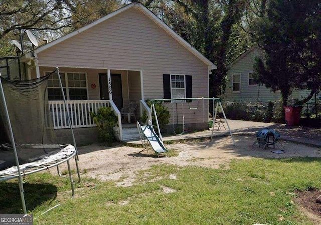 exterior space with a trampoline, a porch, and a front lawn