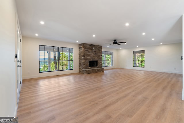 unfurnished living room with a fireplace, light hardwood / wood-style floors, and ceiling fan