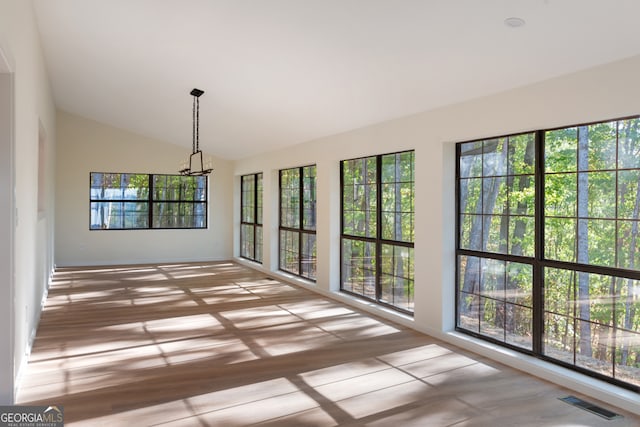 unfurnished sunroom with a healthy amount of sunlight and vaulted ceiling