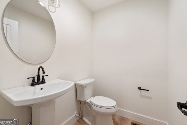 bathroom with toilet and hardwood / wood-style flooring