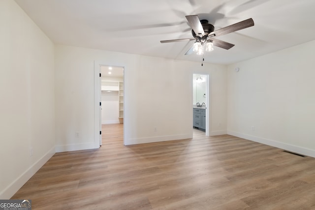 empty room with ceiling fan and light wood-type flooring