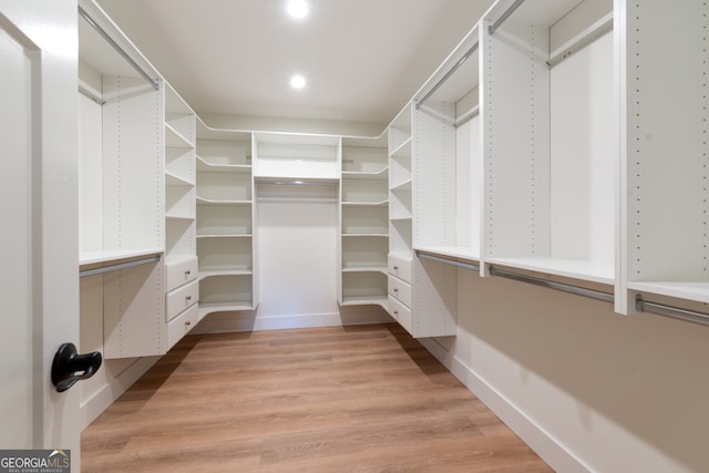 walk in closet with light hardwood / wood-style flooring