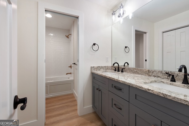 bathroom with vanity, tiled shower / bath, and hardwood / wood-style flooring