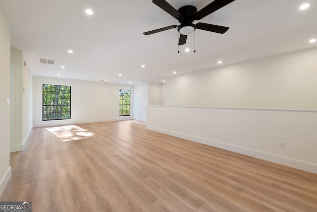 unfurnished room featuring light wood-type flooring, a healthy amount of sunlight, and ceiling fan