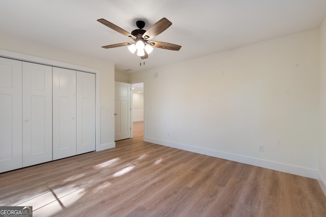 unfurnished bedroom featuring a closet, light hardwood / wood-style floors, and ceiling fan