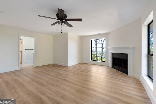 unfurnished living room featuring light hardwood / wood-style flooring, a fireplace, and ceiling fan