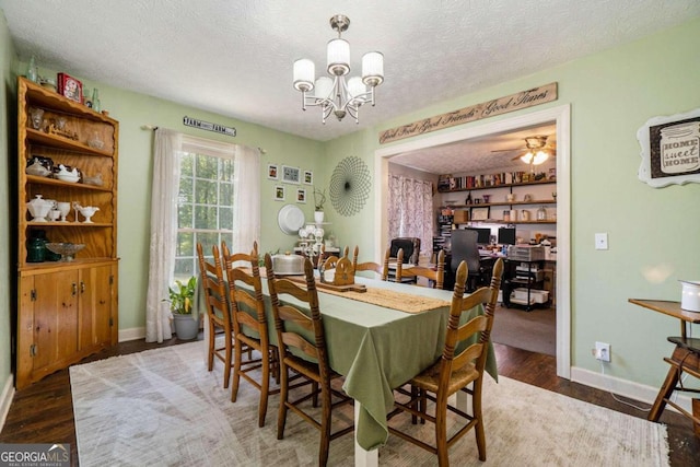 dining room featuring ceiling fan with notable chandelier, dark hardwood / wood-style floors, and a textured ceiling