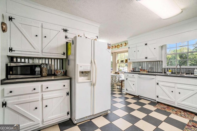 kitchen featuring a textured ceiling, plenty of natural light, sink, and white appliances