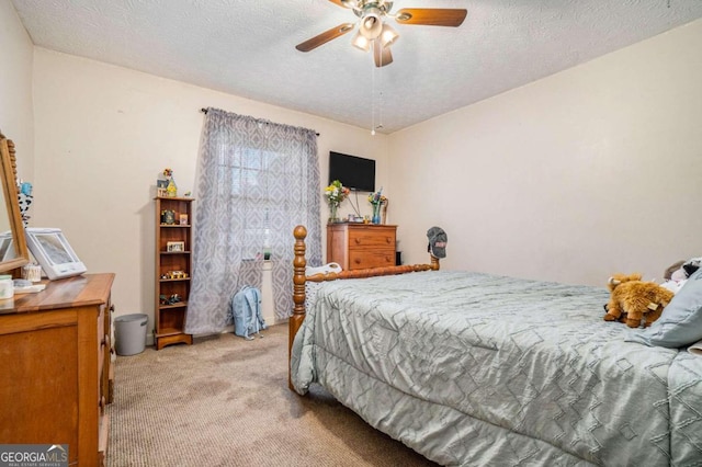 carpeted bedroom with ceiling fan and a textured ceiling