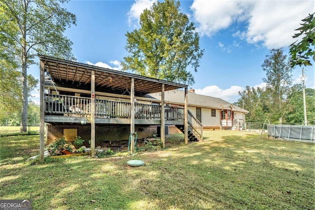 rear view of house featuring a deck and a yard