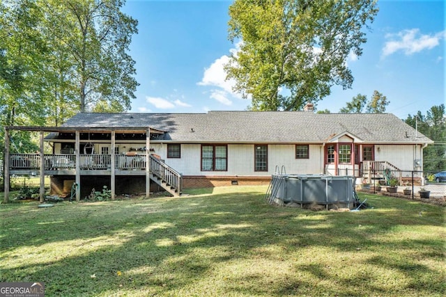 back of house featuring a lawn and a swimming pool side deck