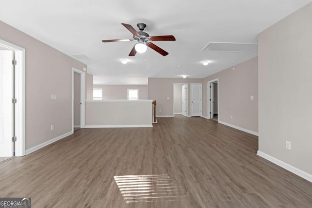 unfurnished living room with ceiling fan and dark wood-type flooring