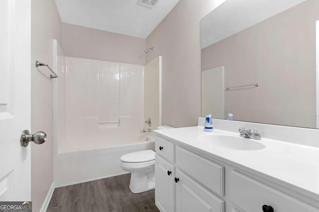 full bathroom featuring hardwood / wood-style floors, bathing tub / shower combination, vanity, and toilet