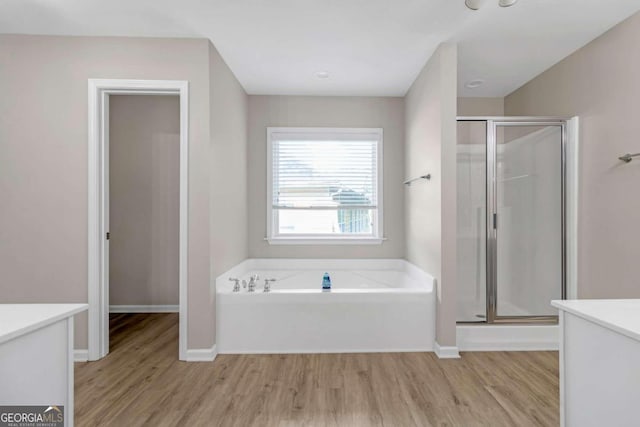 bathroom with independent shower and bath, vanity, and hardwood / wood-style floors