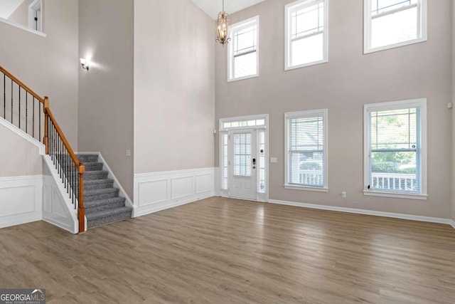 entrance foyer with a notable chandelier, hardwood / wood-style flooring, and a high ceiling