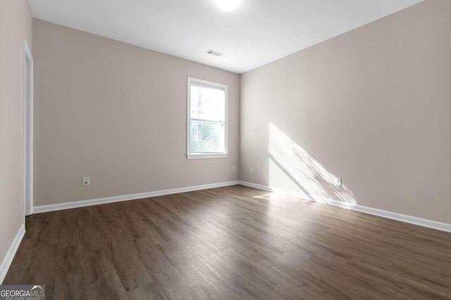 spare room with dark hardwood / wood-style floors