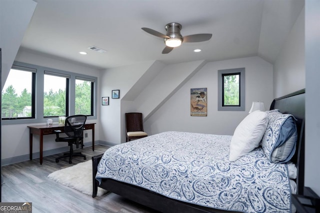 bedroom featuring hardwood / wood-style flooring, multiple windows, ceiling fan, and lofted ceiling