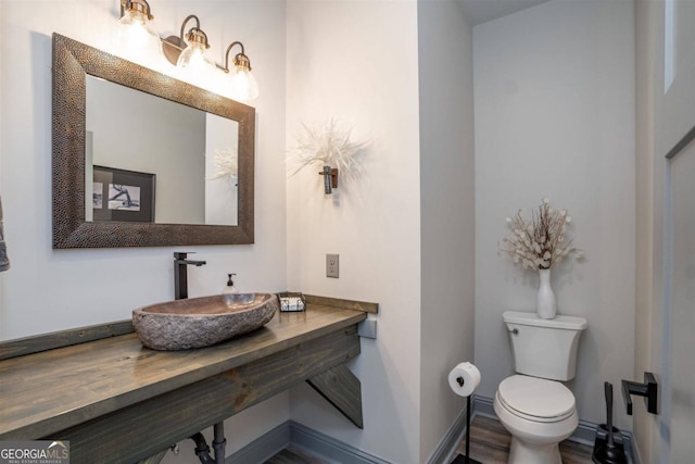 bathroom featuring wood-type flooring, sink, and toilet