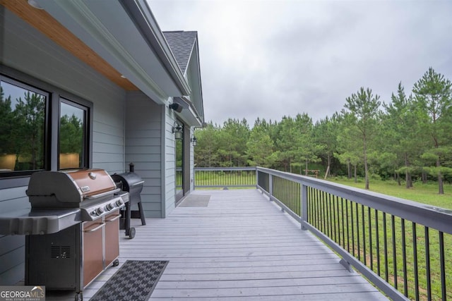 wooden deck with area for grilling and a lawn