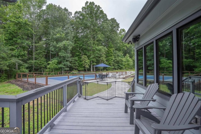 wooden terrace featuring a fenced in pool and a yard