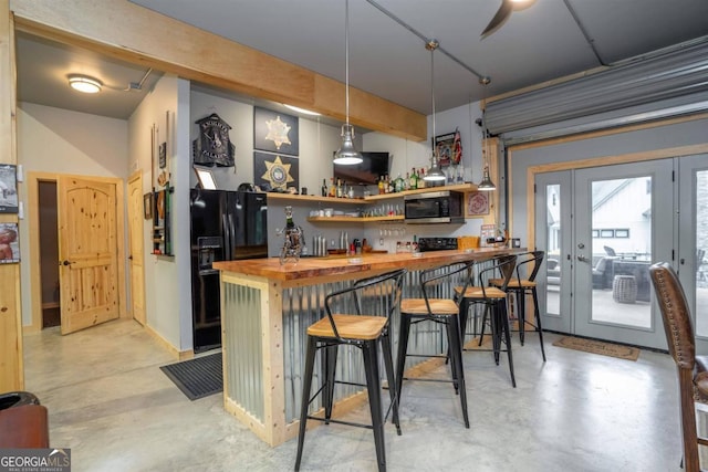 bar featuring black fridge, wooden counters, and decorative light fixtures