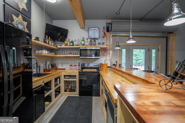 kitchen featuring decorative light fixtures, black electric range, butcher block counters, and sink