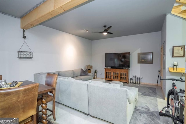 living room featuring beamed ceiling and ceiling fan