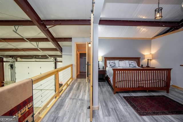 bedroom with dark hardwood / wood-style floors and beam ceiling