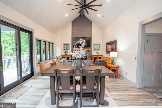 dining area featuring high vaulted ceiling, light hardwood / wood-style flooring, and ceiling fan