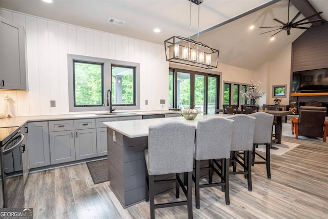 kitchen featuring a healthy amount of sunlight, hanging light fixtures, a large fireplace, and sink