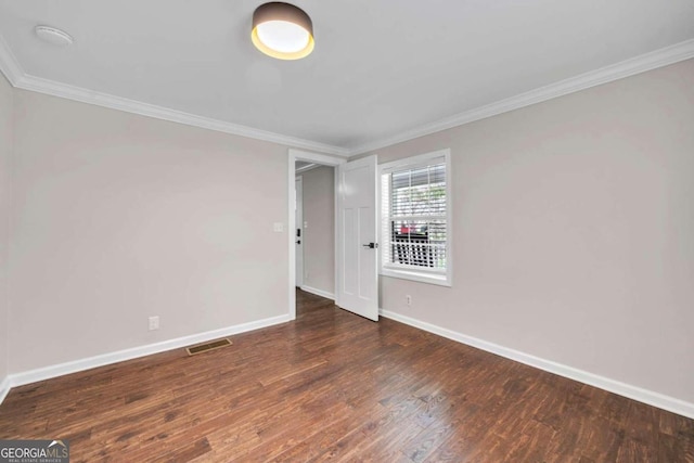 unfurnished room featuring ornamental molding and dark wood-type flooring