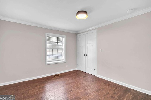 laundry room with stacked washer / dryer and dark hardwood / wood-style floors