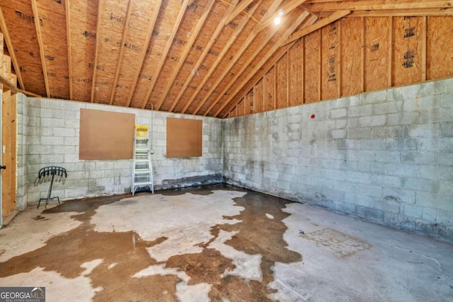 miscellaneous room featuring concrete flooring and lofted ceiling