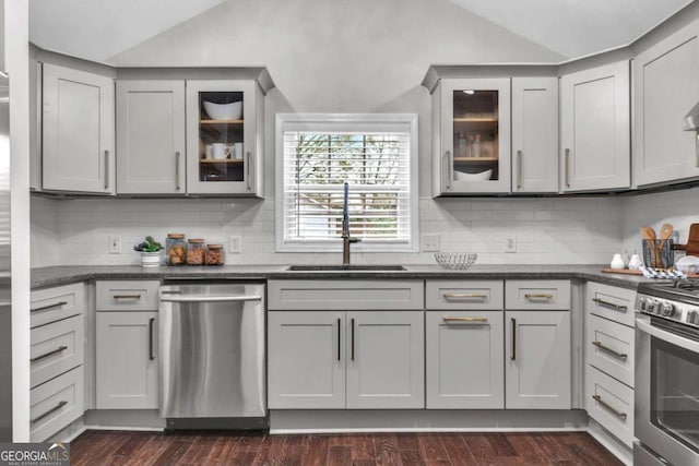 kitchen featuring sink, dark wood-type flooring, gray cabinets, stainless steel appliances, and vaulted ceiling