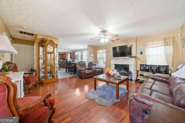 living room with ceiling fan, hardwood / wood-style floors, and a textured ceiling