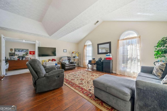 living room with lofted ceiling, dark hardwood / wood-style flooring, a wealth of natural light, and a textured ceiling