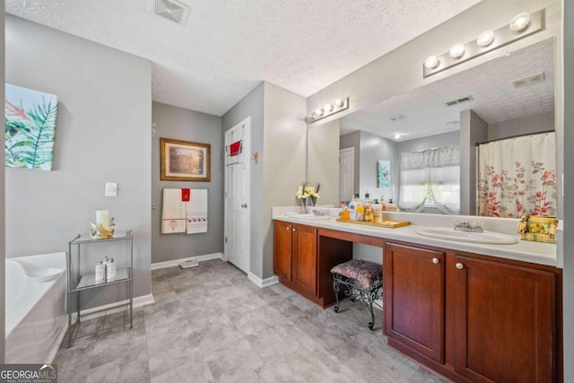 bathroom featuring vanity, a textured ceiling, and a washtub