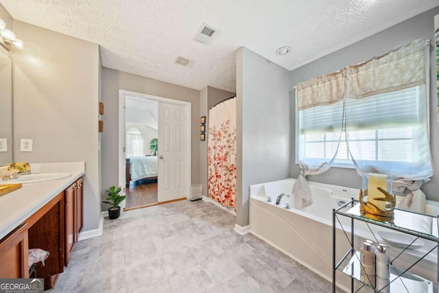 bathroom with vanity, independent shower and bath, and a textured ceiling