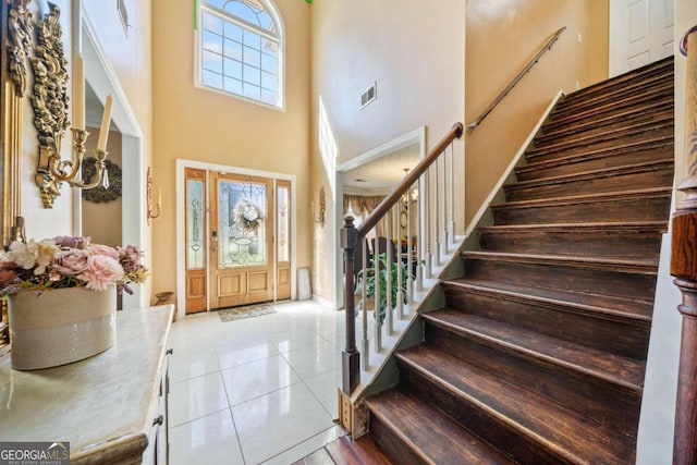 tiled foyer with a towering ceiling and plenty of natural light