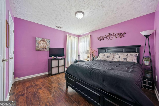 bedroom featuring dark wood-type flooring and a textured ceiling