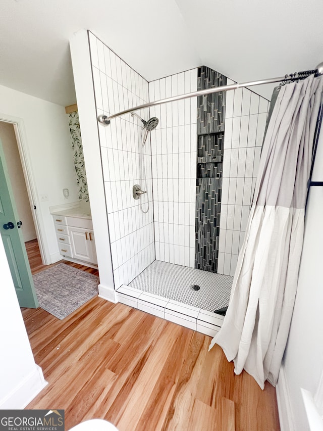 bathroom featuring hardwood / wood-style floors and walk in shower