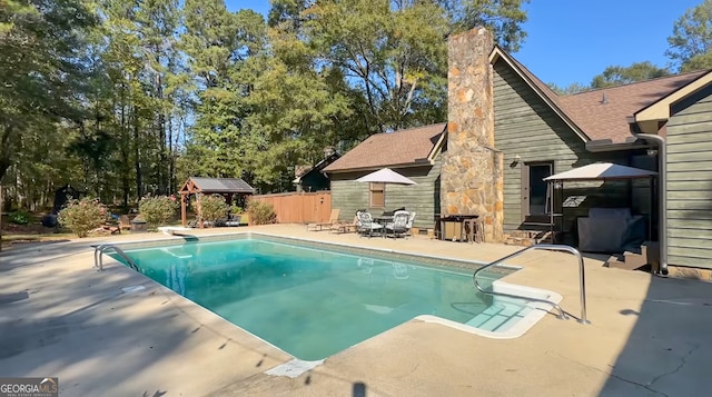 view of swimming pool featuring a gazebo, a patio area, and a diving board