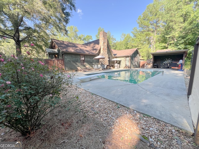 view of swimming pool with a patio area and a diving board