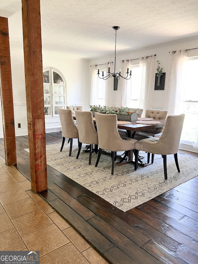 dining room with hardwood / wood-style flooring, a textured ceiling, and a notable chandelier